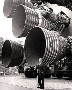 Wernher von Braun vor den Triebwerken einer Saturn V